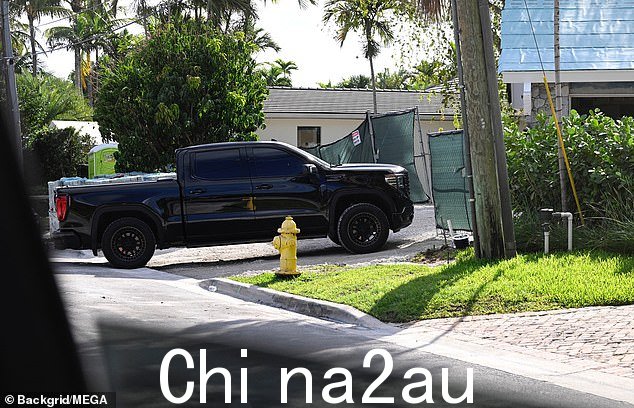 一辆闪亮的黑色皮卡车停在住宅外