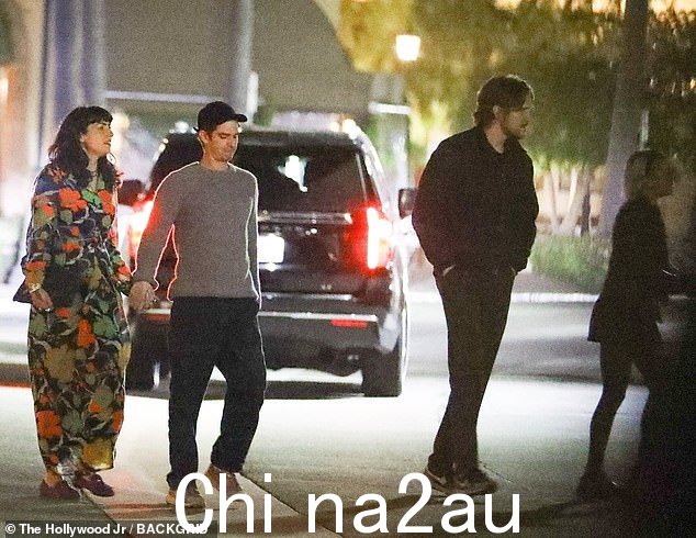 演员在南加州冒着雨夜时添加了一条深色裤子和多色柔和的运动鞋