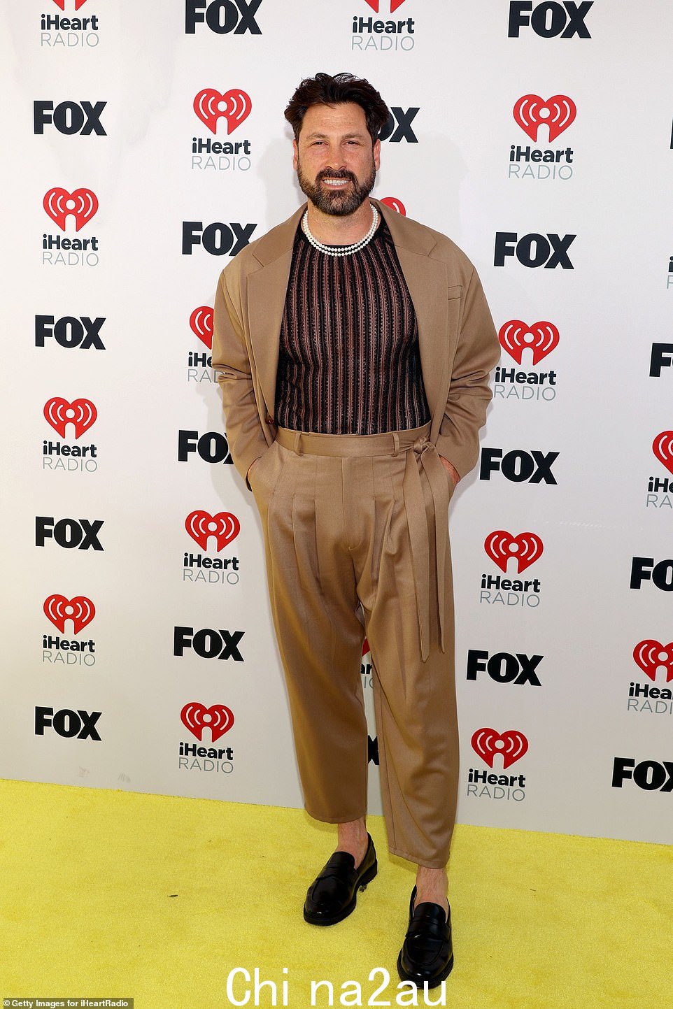 Maksim Chmerkovskiy,44 岁,穿着浅棕色西装搭配褶皱裤,毫不费力地显得很酷。里面穿着一件透明的黑色衬衫,展示了他轮廓分明的躯干