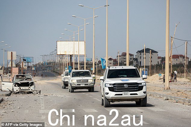 2024 年 4 月 1 日,联合国车辆在加沙城的道路上驶过一辆被毁坏的汽车