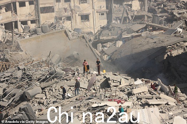 2024 年 4 月 1 日,巴勒斯坦人聚集在加沙代尔巴拉赫被烧毁和毁坏的 Al-Shifa 医院周围。包括该医院在内的许多建筑物在空袭中遭到严重损坏