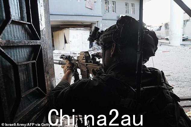 以色列军队于 2024 年 4 月 1 日发布的照片中,一名以色列士兵在和他的部队在加沙地带执行任务时手持枪