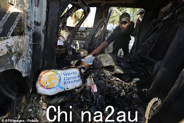 巴勒斯坦人在加沙地带代尔巴拉赫检查一辆带有世界中央厨房标志的车辆,该车辆在以色列空袭中被毁坏