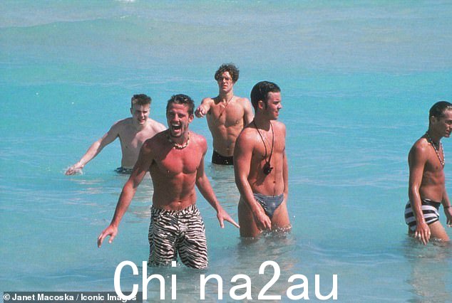 他们都穿着小短裤,把手伸进海里嬉戏