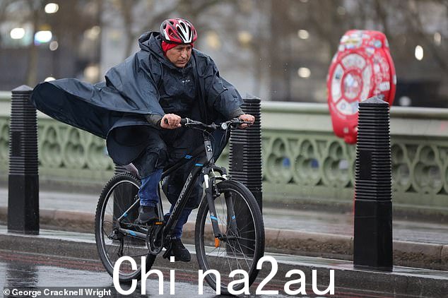 今天早上,一名骑自行车的人穿过伦敦潮湿多风的威斯敏斯特桥