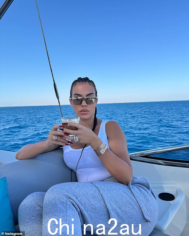 这位美女在喝着早晨咖啡时,穿着白色系带上衣和灰色慢跑裤,看起来也很时尚