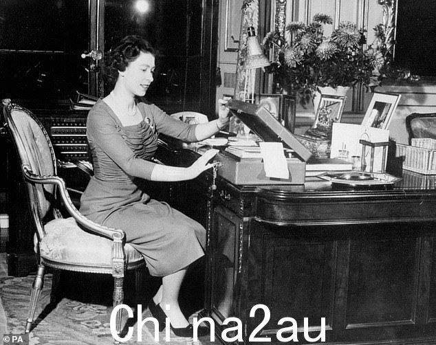 伊丽莎白二世在白金汉宫的办公桌上摆着红色盒子工作