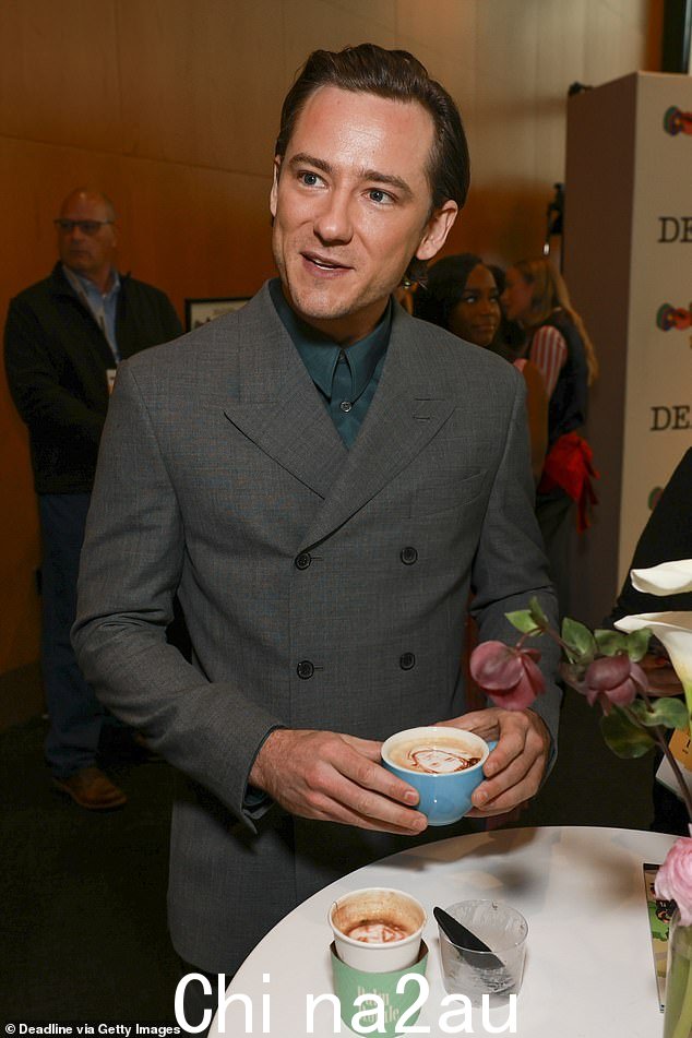刘易斯·普尔曼 (Lewis Pullman) 身穿双排扣灰色西装,搭配森林绿色纽扣衬衫,看起来很帅气