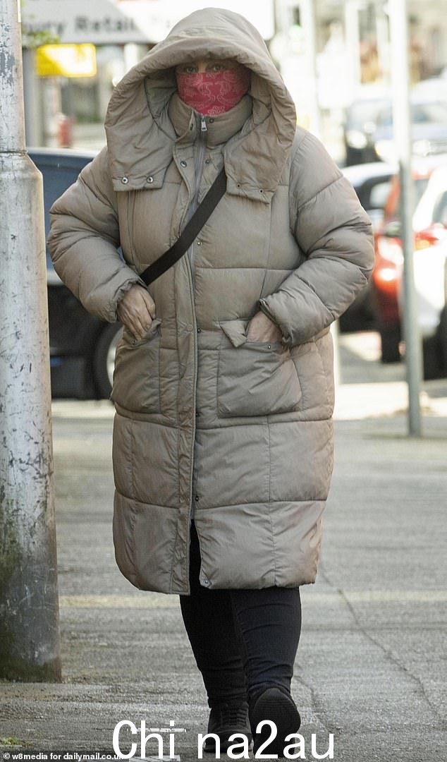 马修斯穿着米色长款羽绒服,用粉色围巾遮住脸,从她破旧的公寓里走出来,大喊“我是无辜的,别打扰我。” class=