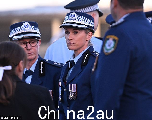 英雄警察艾米·斯科特督察(如图中)在到达为袭击受害者守夜的地方时受到了同事们的拥抱