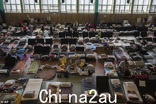 2022 年 3 月 15 日,逃离乌克兰战争的人们在波兰和乌克兰边境梅迪卡的一个用作难民中心的室内体育场内休息