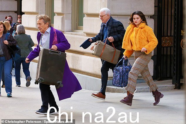 马丁也升当三人走向附近的出租车时,他拖着一个大的棕色手提箱