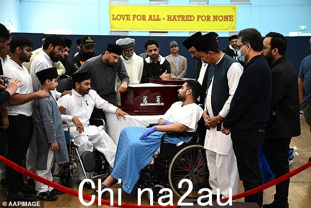保安 Muhammad Taha(右)与同事的大哥 Muzafar Ahmad Tahir(左坐)交谈