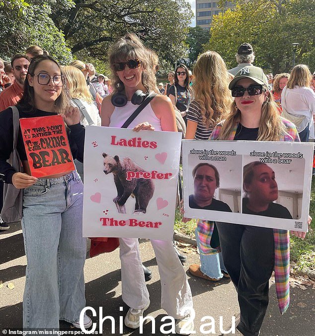 参加悉尼集会呼吁结束性别暴力的女性举着牌子,上面写着“在这一点上我宁愿是该死的熊”和“女士们更喜欢熊'