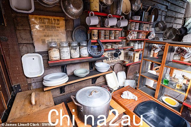 厨房区域的视图,可以看到架子上展示着罐子和容器,挂着各种锅碗瓢盆