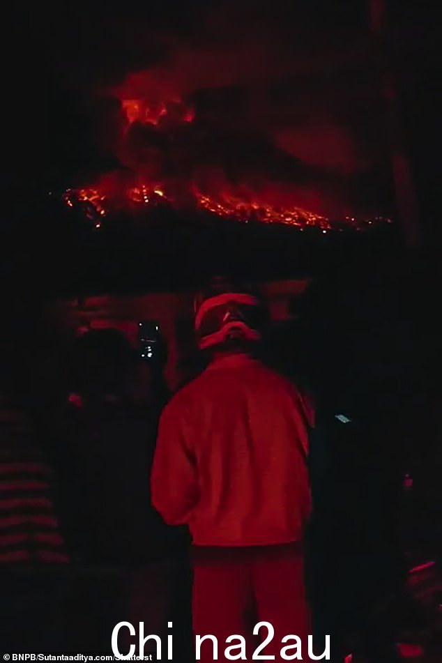 西塔罗群岛鲁昂火山喷发时喷出炽热的熔岩和火山灰,居民们惊愕地看着