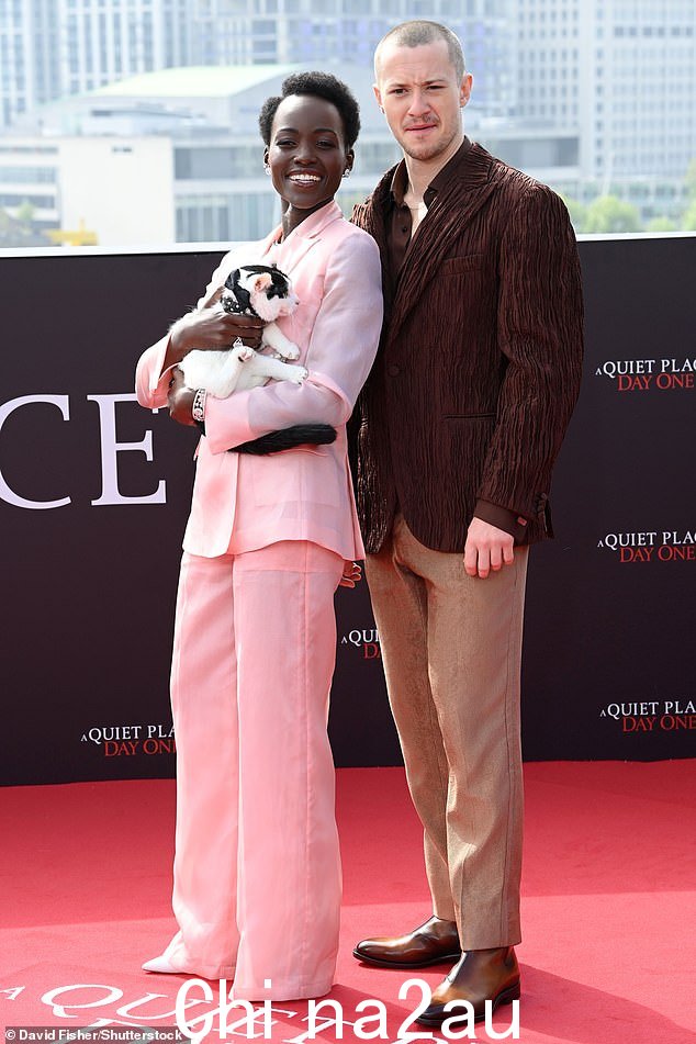 Lupita 和她的搭档 Joseph Quinn 一起参加了拍照留念,他穿着深棕色西装外套,搭配配套的衬衫和棕褐色裤子,看起来衣冠楚楚
