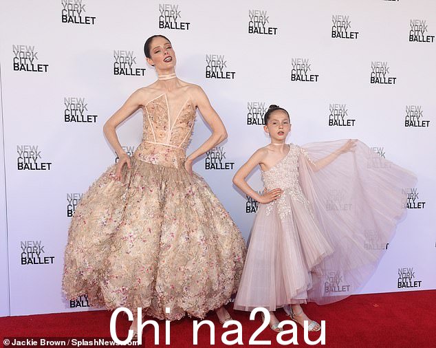 她可爱的 9 岁女儿 Ioni James Conran 也加入了她的行列,她穿着一件可爱的腮红连衣裙,自豪地在她母亲身边摆出姿势
