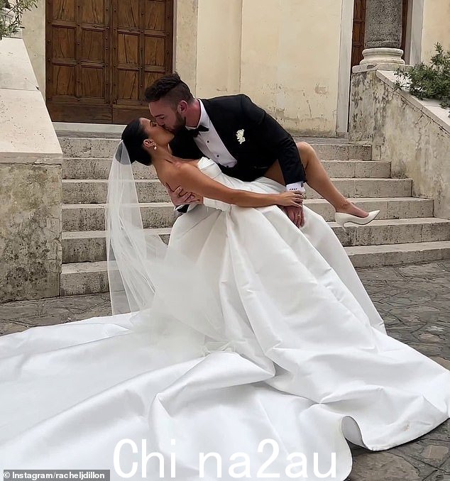 这对新婚夫妇在交换誓言后在一栋令人惊叹的建筑外摆出接吻姿势,瑞秋穿着美丽的新娘礼服,看起来令人难以置信