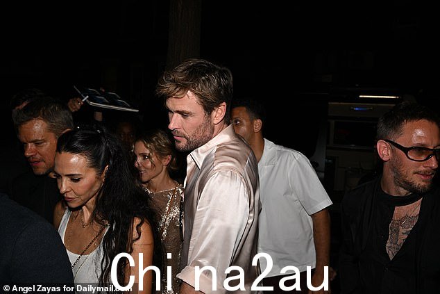 脱掉奶油色西装外套和马甲后,克里斯·海姆斯沃斯 (Chris Hemsworth) 走进派对时只穿了一件鲑鱼粉色衬衫