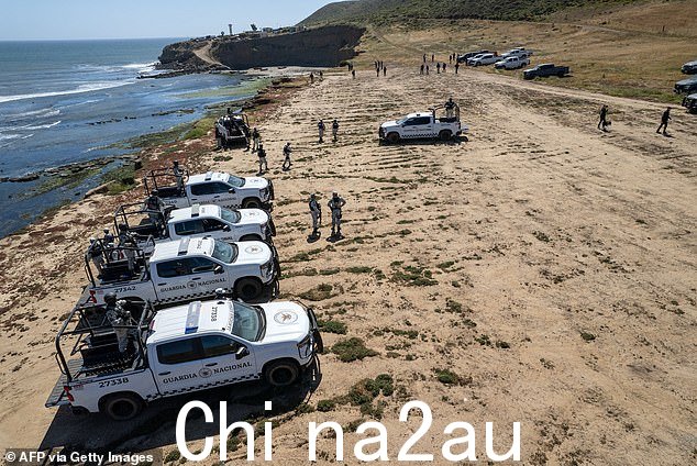 一排国民警卫队车辆守卫着海滩,州检察官正在搜查三名冲浪者失踪前露营的地点