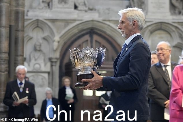 前 F1 赛车手达蒙·希尔 (Damon Hill) 在今早的仪式上举起奖杯