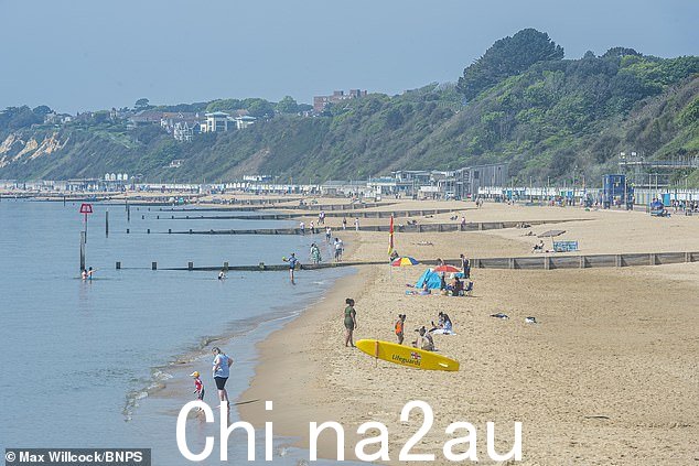 伯恩茅斯:人们在多塞特郡的海滩上享受炎热的天气和明媚的阳光