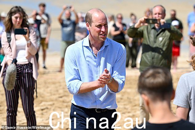威尔士亲王威廉王子在 Fistral 海滩与当地儿童交谈