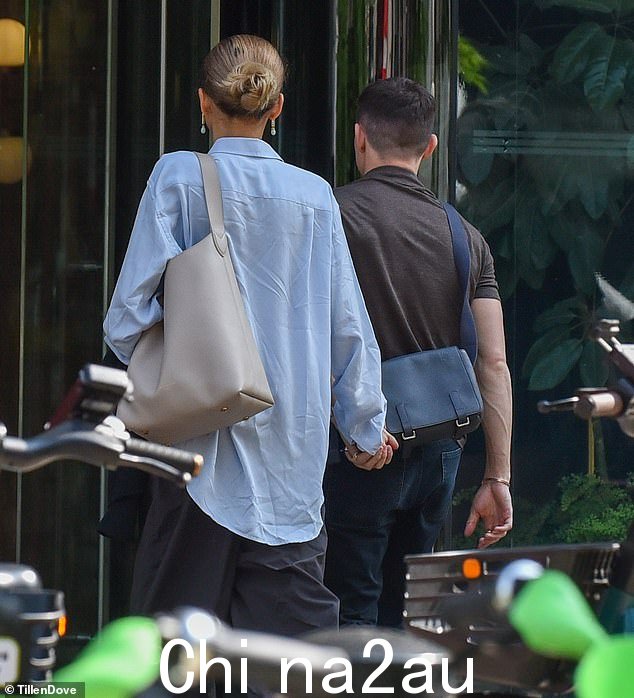 Zendaya 在和 Tom 走进餐馆时选择了一件超大的淡蓝色衬衫和炭色裤子