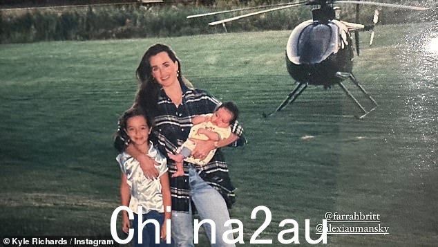 在另一张照片中,这位真人秀明星穿着一件超大的蓝色格子衬衫和牛仔裤,抱着婴儿亚历克西斯,她用一只手臂搂着女儿法拉,站在湖边,站在直升机上。悬停在背景中
