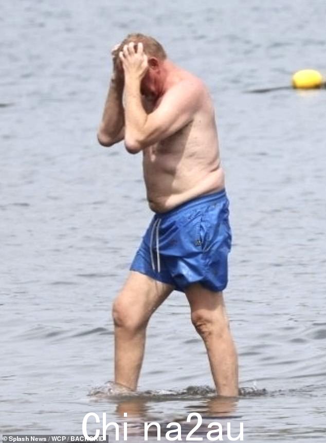 他在海滩漫步后在水中清凉