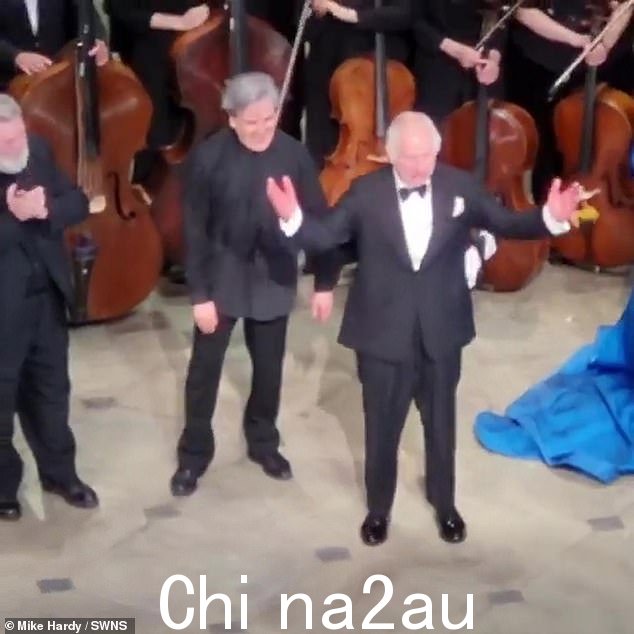 国王举起双手并拍拍帕帕诺的肩膀表示祝贺,以表彰他担任音乐总监 22 年