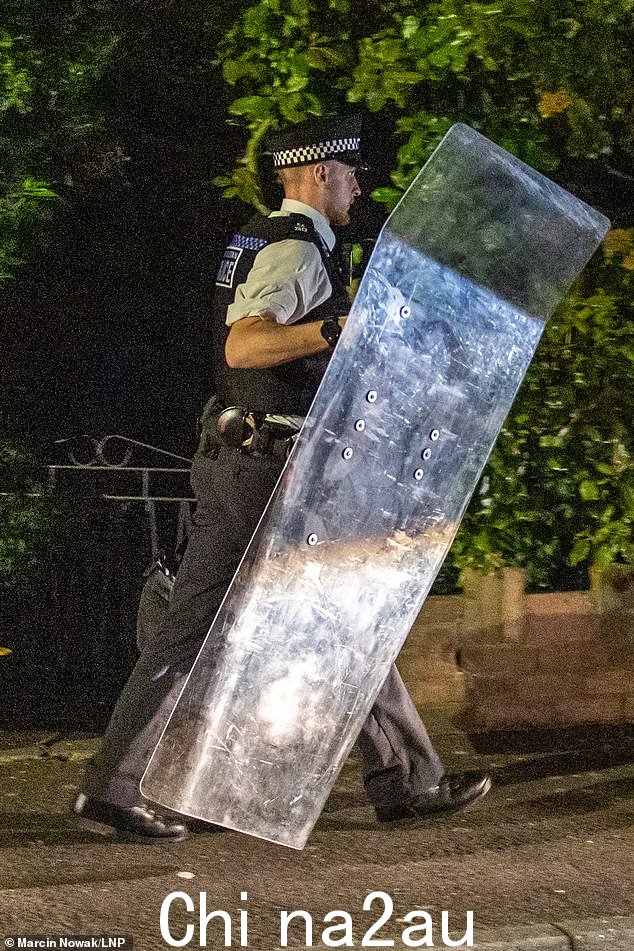 在噩梦般的袭击之后,一名警察携带防暴盾牌出现在街上