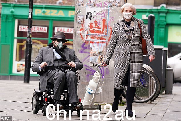 米兰达,42 岁,她的丈夫坐在电动轮椅上,他声称因为长期新冠疫情的影响而需要这种轮椅