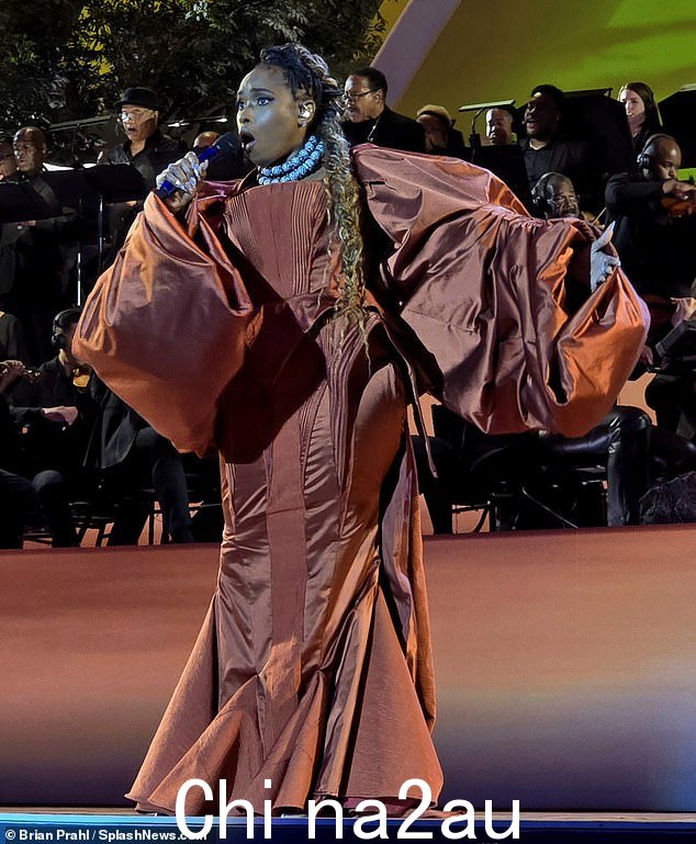 这位 42 岁的歌手穿着戏剧性的青铜色长袍表演,礼服配有巨大的气球袖和美人鱼尾巴风格的大褶裙,表演令人惊叹