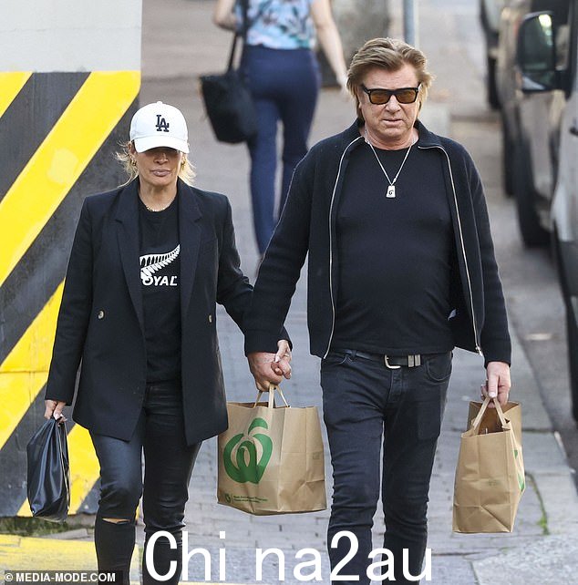 这对新人牵着手走路,表现得很舒适,尽管理查德每只手上都拿着一袋购物