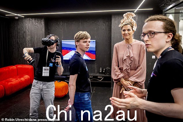 一名学生演示了虚拟现实耳机,另一名学生则解释了他们的工作