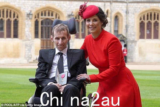 前橄榄球联盟球员 Rob Burrow 和他的妻子 Lindsey 在 2022 年在温莎城堡被授予 MBE 后与他的奖牌合影