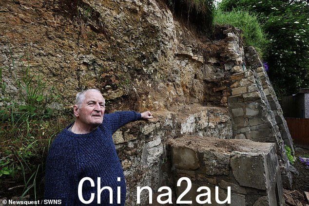 贝利先生站在受损的墙旁边,他说这堵墙在今年早些时候就倒塌了