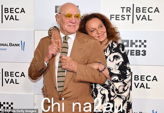 她得到了亿万富翁丈夫巴里·迪勒 (Barry Diller) 的支持,他穿着棕色西装,搭配配套的条纹领带,戴着黄色眼镜