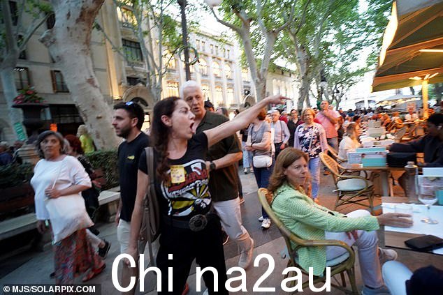 抗议者对在帕尔马享用晚餐和饮料的震惊度假者大喊大叫