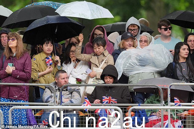 今天在伦敦皇家军队阅兵前,皇家球迷试图躲避大雨