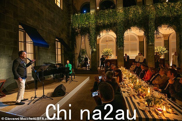 哈利路亚歌手在晚宴活动中表演时穿着黑色夹克和白色裤子