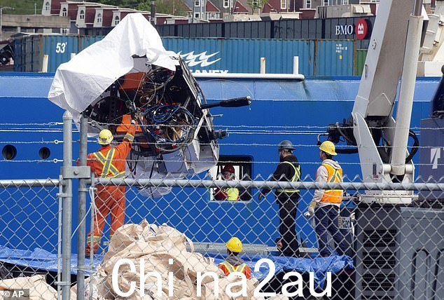 从泰坦尼克号残骸附近的海底回收的泰坦潜水器碎片,从加拿大海岸警卫队码头的 Horizon Arctic 号船上卸下