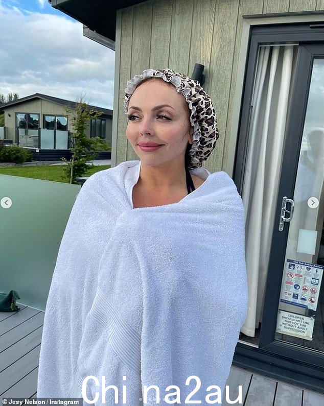 Jesy 戴着豹纹浴帽保持头发干燥,以便在小屋的热水浴缸中畅游