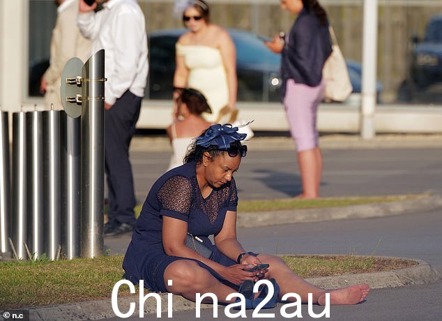 一个穿着蓝色连衣裙的女人脱掉高跟鞋后赤脚坐在地上