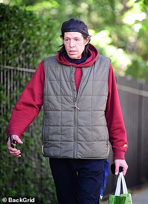 尽管天气炎热,电影制片人还是在海军蓝上衣外穿了一件红色耐克连帽衫,分层分层
