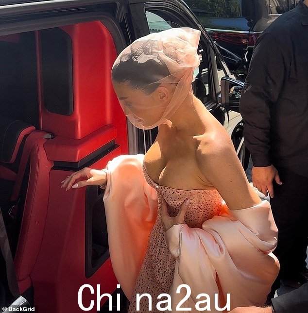 凯莉在上车时努力控制住她在无肩带连衣裙中的丰满乳沟