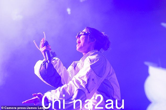 梅尔穿着白色运动服在舞台上跳来跳去,看起来很酷