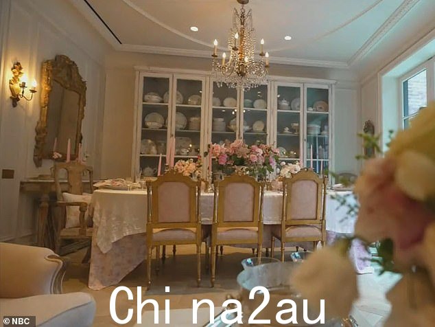 铺着布的餐桌两侧是金色椅子,还有令人惊叹的枝形吊灯和各种鲜花花束